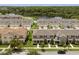 Aerial view of townhomes with garages and manicured lawns near a lake at 2966 Aqua Virgo Loop # 16, Orlando, FL 32837