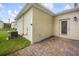 An outdoor patio features brick pavers, a back door, and green grass near the AC unit at 2966 Aqua Virgo Loop # 16, Orlando, FL 32837