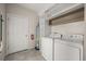 Bright laundry room features a modern washer, dryer, tiled floors, and shelving for storage at 2966 Aqua Virgo Loop # 16, Orlando, FL 32837