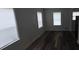 Bright living room with multiple windows and wood-look floors, offering ample natural light at 3029 Azalea Ave, Lake Wales, FL 33898