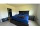 Comfortable bedroom featuring a large bed with a blue comforter and dark wood furnishings at 30346 Armenia Rd, Leesburg, FL 34748