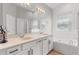 Bright bathroom with dual sinks, soaking tub, and a glass-enclosed shower at 3310 Cat Brier Trl, Harmony, FL 34773