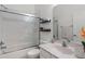 Bright bathroom features a shower-over-tub with sliding glass door and vanity with solid surface counter at 3310 Cat Brier Trl, Harmony, FL 34773