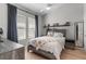 Cozy bedroom with a ceiling fan, two windows, and a shelf with assorted figurines at 3310 Cat Brier Trl, Harmony, FL 34773
