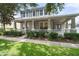 Charming two-story home with a wide porch, columns, well-manicured landscaping, and sidewalk appeal at 3310 Cat Brier Trl, Harmony, FL 34773