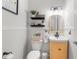 Cozy half bathroom with a stylish vanity, framed mirror, and tiled walls, offering a convenient space for guests at 3310 Cat Brier Trl, Harmony, FL 34773