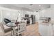 Bright eat-in kitchen with stainless steel appliances, white cabinets, and wood-look flooring at 3310 Cat Brier Trl, Harmony, FL 34773