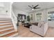 Bright living room with modern ceiling fan, wood flooring, and staircase in a modern-style home at 3310 Cat Brier Trl, Harmony, FL 34773