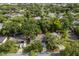 A high aerial shot showcasing a home nestled among mature trees in a well established neighborhood on a sunny day at 410 Kentia Rd, Casselberry, FL 32707