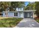 Charming blue home with well-maintained lawn and covered carport entry at 410 Kentia Rd, Casselberry, FL 32707