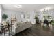Open-concept living room flows to dining area, showcasing modern lighting and sleek, dark wood flooring at 410 Kentia Rd, Casselberry, FL 32707