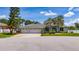 Charming single-story home with a three-car garage, mature trees, and well-maintained landscaping on a sunny day at 415 Smiley Ct, Winter Haven, FL 33884