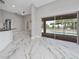 Bright living room featuring marble floors and a view of the screened-in pool area at 415 Smiley Ct, Winter Haven, FL 33884