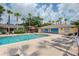 Community pool with palm trees and lounge chairs on a sunny day at 4768 Tangerine Ave # 4768, Winter Park, FL 32792