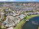 Aerial view of community's luxurious amenities, with pools, a lazy river, and clubhouse, all nestled by a lake at 4981 Windermere Ave, Kissimmee, FL 34746