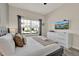 Bright bedroom features a comfortable bed, modern dresser with TV, and ample natural light at 4981 Windermere Ave, Kissimmee, FL 34746
