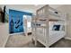 Bright bedroom featuring two white bunk beds, blue accent wall, and charming Peter Pan themed decorations at 4981 Windermere Ave, Kissimmee, FL 34746