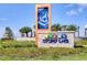 Community entrance sign with hammock art, landscaping, and stone base at 4981 Windermere Ave, Kissimmee, FL 34746