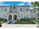 Inviting gray two-story townhome with arched entryway and lush landscaping, creating a welcoming curb appeal at 4981 Windermere Ave, Kissimmee, FL 34746
