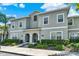Inviting gray two-story townhome with neatly manicured landscaping, and white trim against a beautiful blue sky at 4981 Windermere Ave, Kissimmee, FL 34746