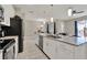 Open kitchen with island barstool seating, sleek stainless appliances, and a view into the dining and living spaces at 4981 Windermere Ave, Kissimmee, FL 34746