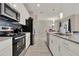 Modern kitchen featuring white cabinets, sleek stainless steel appliances, and a seamless connection to the dining area at 4981 Windermere Ave, Kissimmee, FL 34746