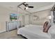Bright bedroom showcases a comfortable bed, modern dresser with mounted TV, and ample natural light at 4981 Windermere Ave, Kissimmee, FL 34746