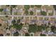 An aerial view of neighborhood streets, manicured lawns, and single Gathering homes with various roof colors at 505 Oak Dr, Tavares, FL 32778