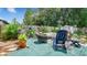 Spacious backyard features a blue rocking chair, outdoor seating, a grill, and lush greenery at 505 Oak Dr, Tavares, FL 32778