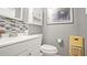 Cozy bathroom featuring a white toilet, white sink, decorative mirror, and natural light at 505 Oak Dr, Tavares, FL 32778
