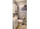 Compact bathroom with white fixtures, cabinet storage, and a wall-mounted decorative art print at 505 Oak Dr, Tavares, FL 32778