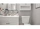 Bathroom featuring a white sink and cabinet and mosaic backsplash and a standard toilet at 505 Oak Dr, Tavares, FL 32778