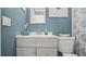 Bright bathroom featuring a white vanity, blue walls, and modern fixtures at 505 Oak Dr, Tavares, FL 32778