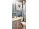 Well-lit bathroom with a vanity sink, decorative shower curtain and complementing blue wall art at 505 Oak Dr, Tavares, FL 32778