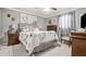 Cozy bedroom with gray walls, a comfortable bed, decorative pillows, and elegant floral artwork at 505 Oak Dr, Tavares, FL 32778