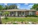 Charming single-story home featuring a well-manicured lawn and cozy front porch with seating at 505 Oak Dr, Tavares, FL 32778