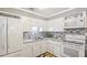 Bright kitchen features white cabinets, white appliances, modern backsplash, and ample counter space at 505 Oak Dr, Tavares, FL 32778