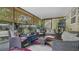 Enclosed sunroom with wicker seating and a colorful rug providing a cozy gathering space at 505 Oak Dr, Tavares, FL 32778