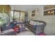 Charming enclosed sunroom featuring wicker furniture, colorful rugs, and inviting decor at 505 Oak Dr, Tavares, FL 32778