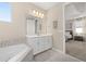 Bathroom with white cabinets, a large mirror, and access to the bedroom at 5133 Citrus Leaf Blvd, Winter Garden, FL 34787