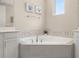 Bright bathroom featuring a garden tub with decorative tile and art pieces above at 5133 Citrus Leaf Blvd, Winter Garden, FL 34787