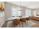 Elegant dining room with a marble tabletop, modern chairs, stylish chandelier, and ample natural light at 5133 Citrus Leaf Blvd, Winter Garden, FL 34787