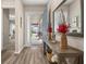 Elegant foyer with hardwood floors, decorative console table, mirror, and a view of the front porch at 5133 Citrus Leaf Blvd, Winter Garden, FL 34787