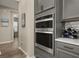 Close-up view of modern kitchen appliances, grey cabinets, quartz countertops, and wine rack details at 5133 Citrus Leaf Blvd, Winter Garden, FL 34787