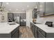 Modern kitchen with grey cabinets, stainless steel appliances, a large island with a sink, and hardwood floors at 5133 Citrus Leaf Blvd, Winter Garden, FL 34787