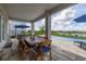 Covered outdoor patio featuring a wooden dining table and a lake view at 5133 Citrus Leaf Blvd, Winter Garden, FL 34787