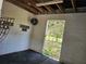 Interior view of barn with concrete block walls, ceiling rafters, and an open doorway leading to the outdoors at 600 Lake Butler Ave, Osteen, FL 32764