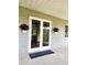 Inviting entryway with double doors, potted plants, and a shaded porch area at 600 Lake Butler Ave, Osteen, FL 32764