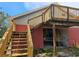 Home exterior with a wooden deck, stairs, and lower-level garage access at 600 Lake Butler Ave, Osteen, FL 32764