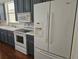 Kitchen featuring white refrigerator, stainless appliances, white countertops and wooden cabinets at 600 Lake Butler Ave, Osteen, FL 32764